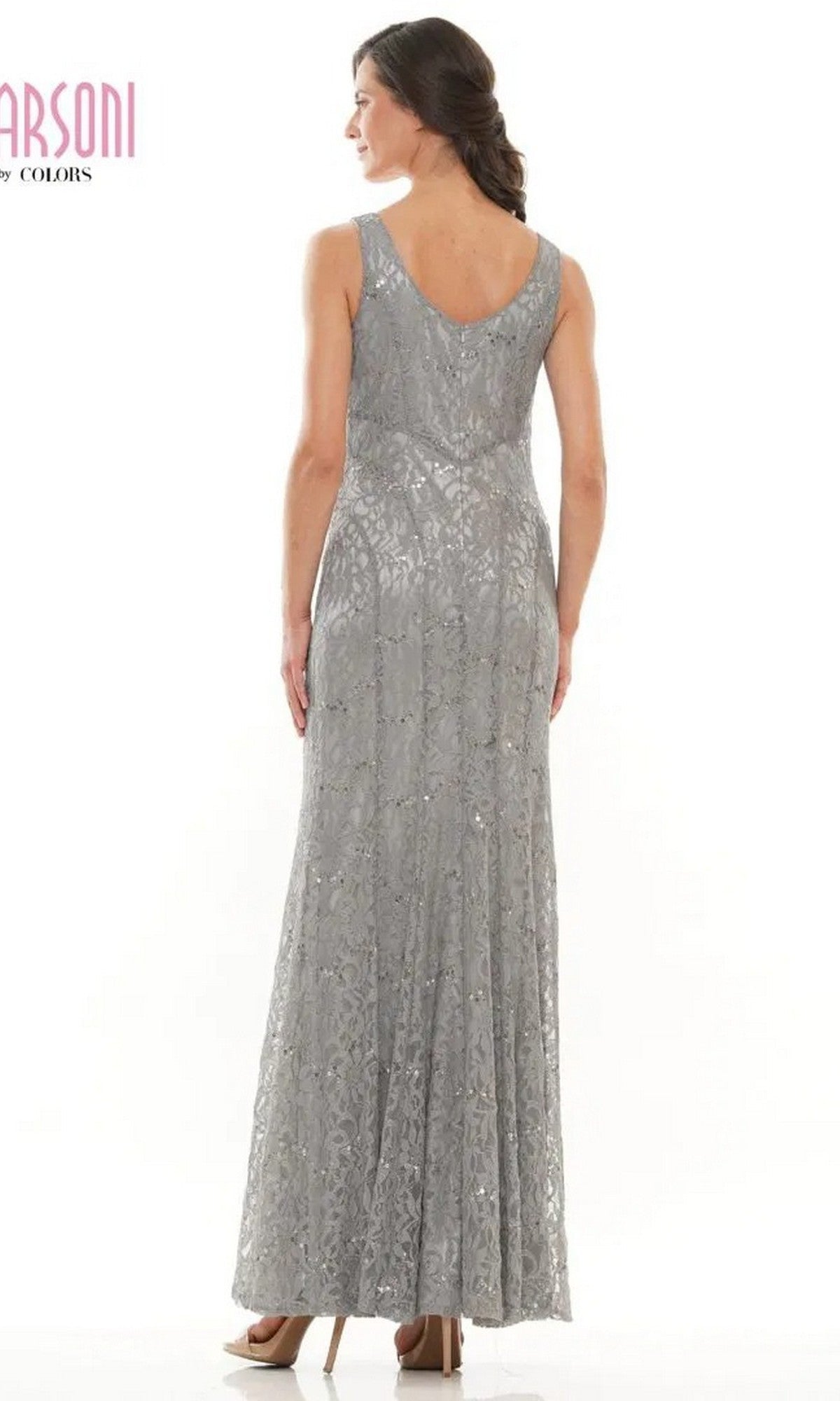 A woman faces away, wearing the Marsoni M301 long formal dress—a sleeveless lace evening gown with a V-shaped back—paired with high heels.
